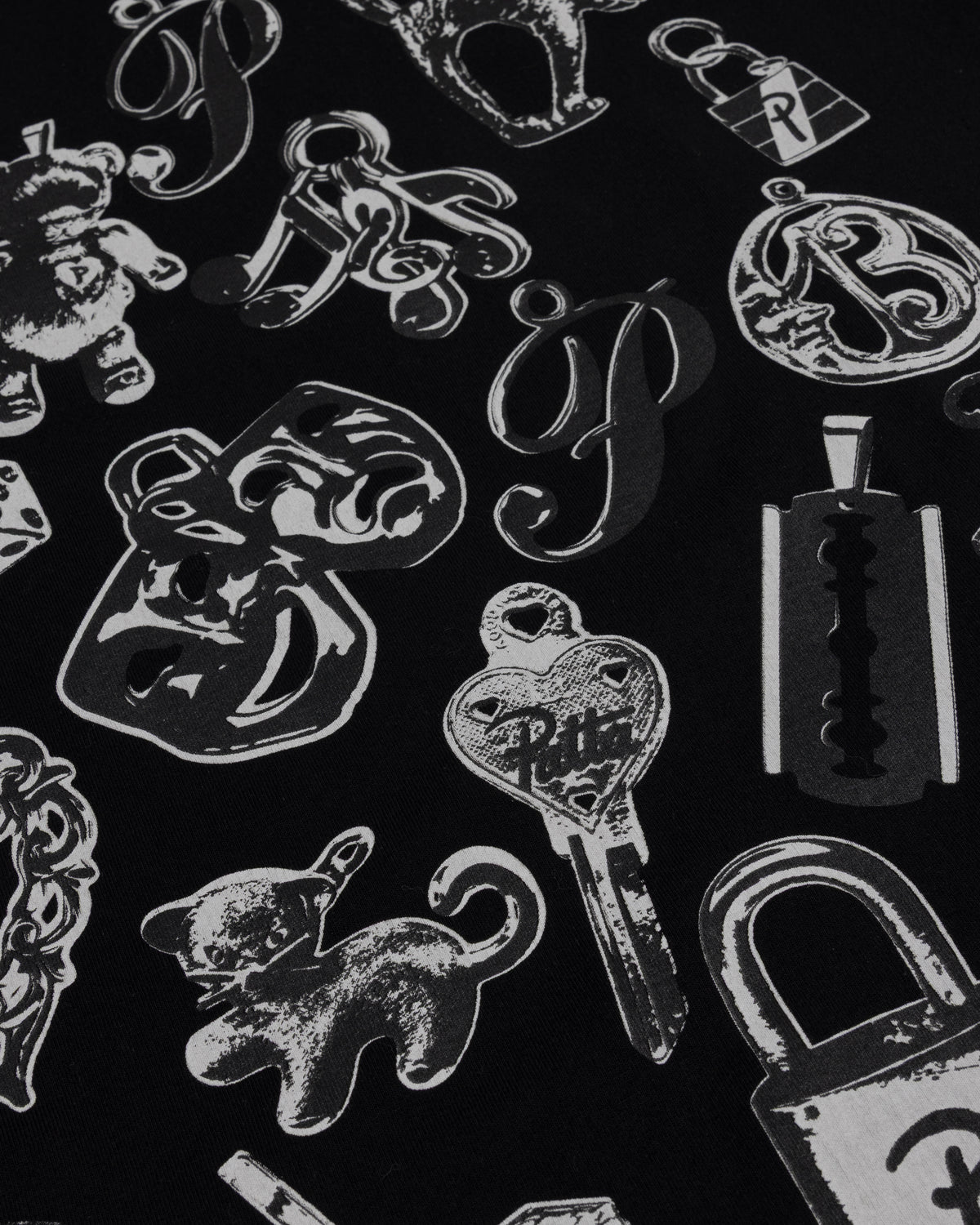 Close-up of the charms graphic print on the black Patta Charm T-Shirt.